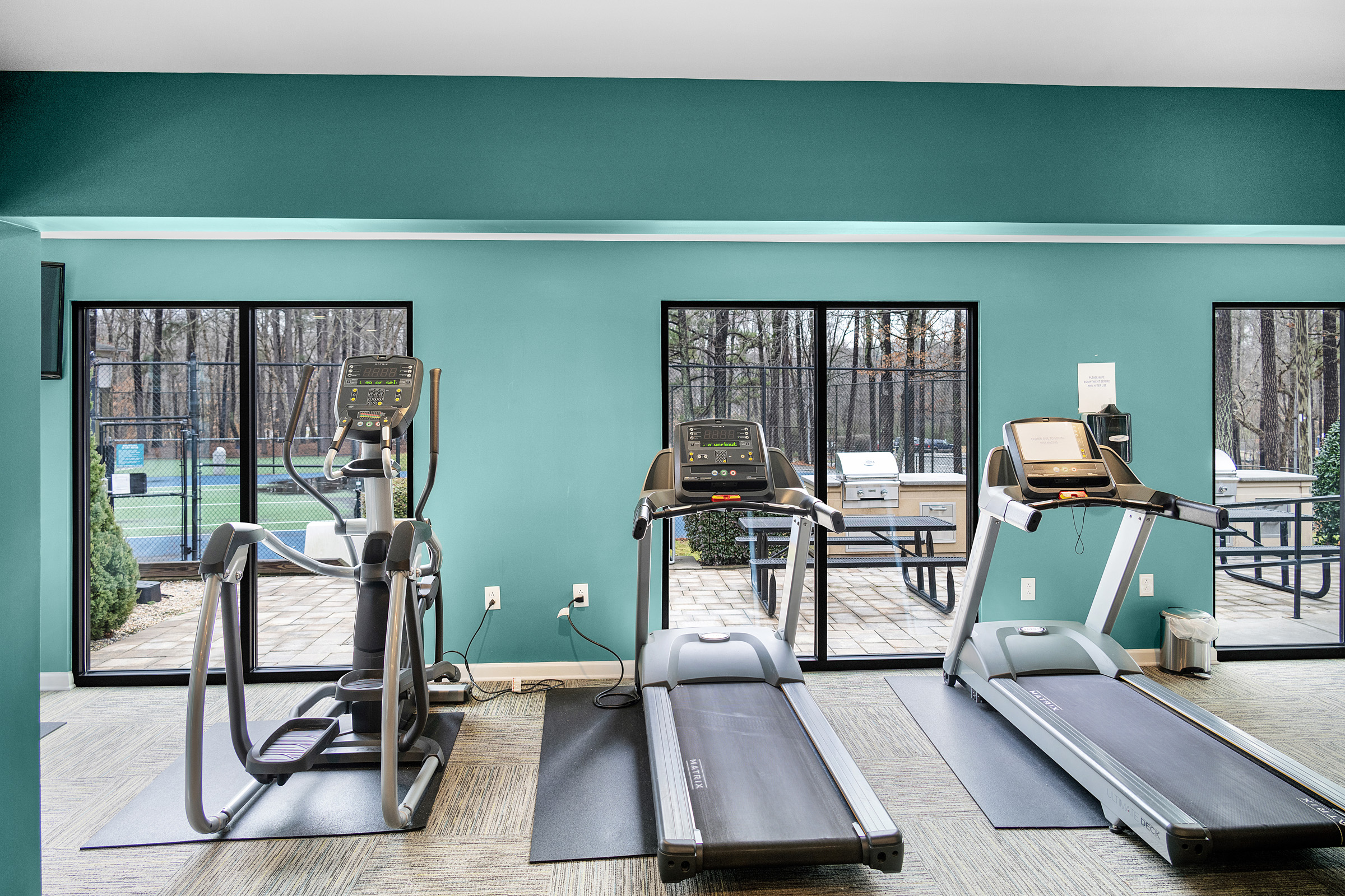 a gym room with treadmills and windows at The  Sawyer