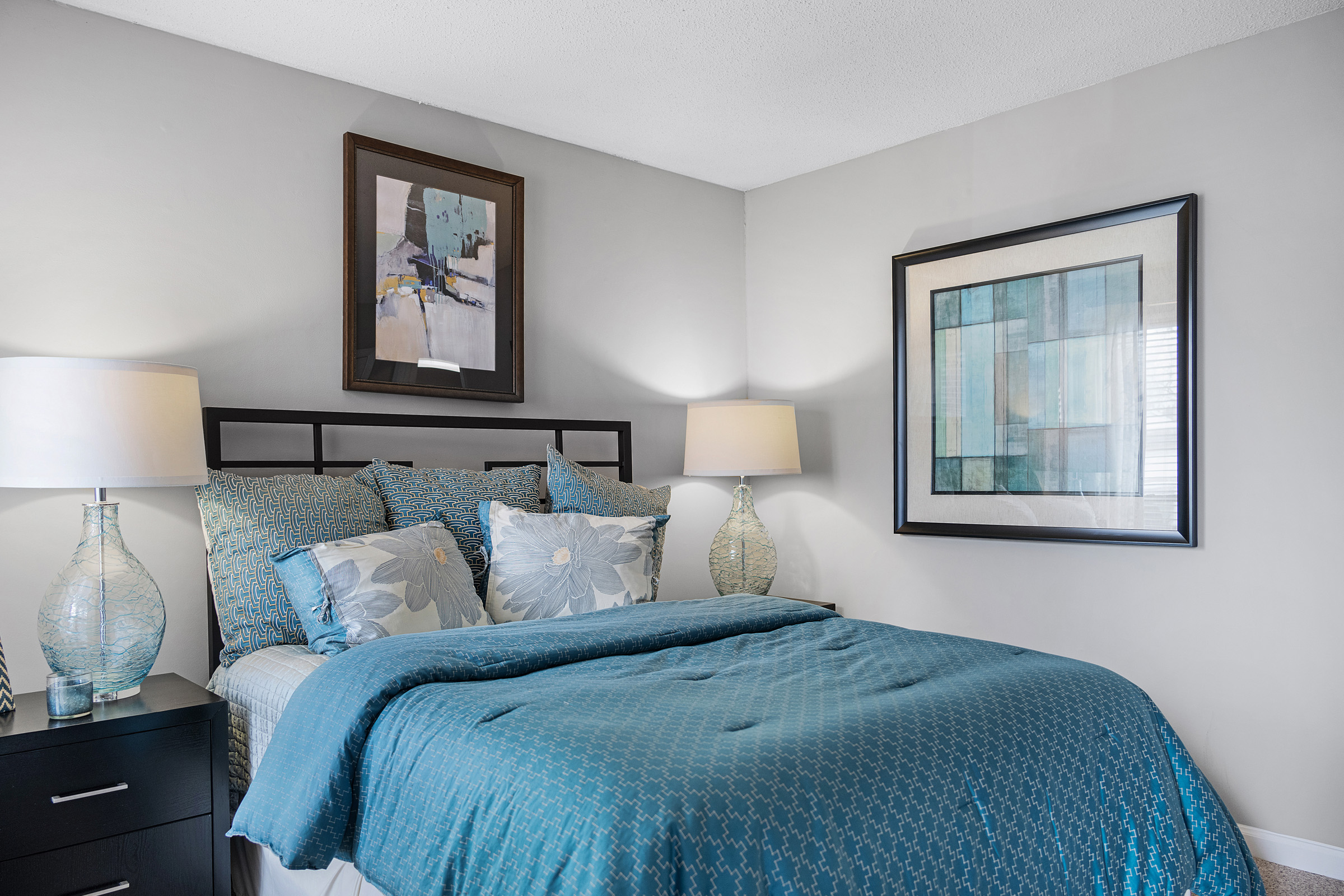 a bedroom with blue bedding and pictures on the wall at The  Sawyer