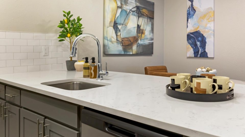 a kitchen with a white counter top and a painting on the wall at The  Sawyer