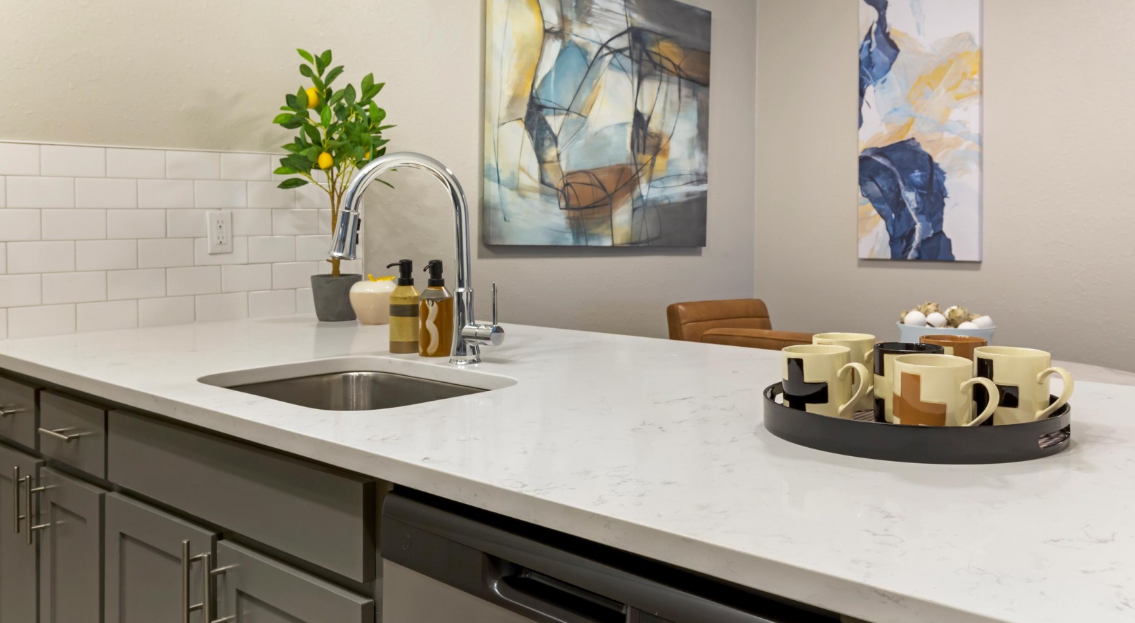 a kitchen with a white counter top and a painting on the wall at The  Sawyer