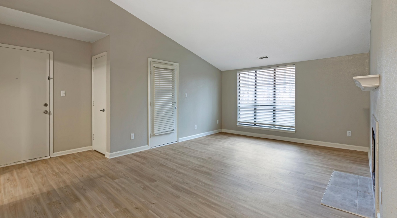 empty living room with hardwood floors and a window at The  Sawyer