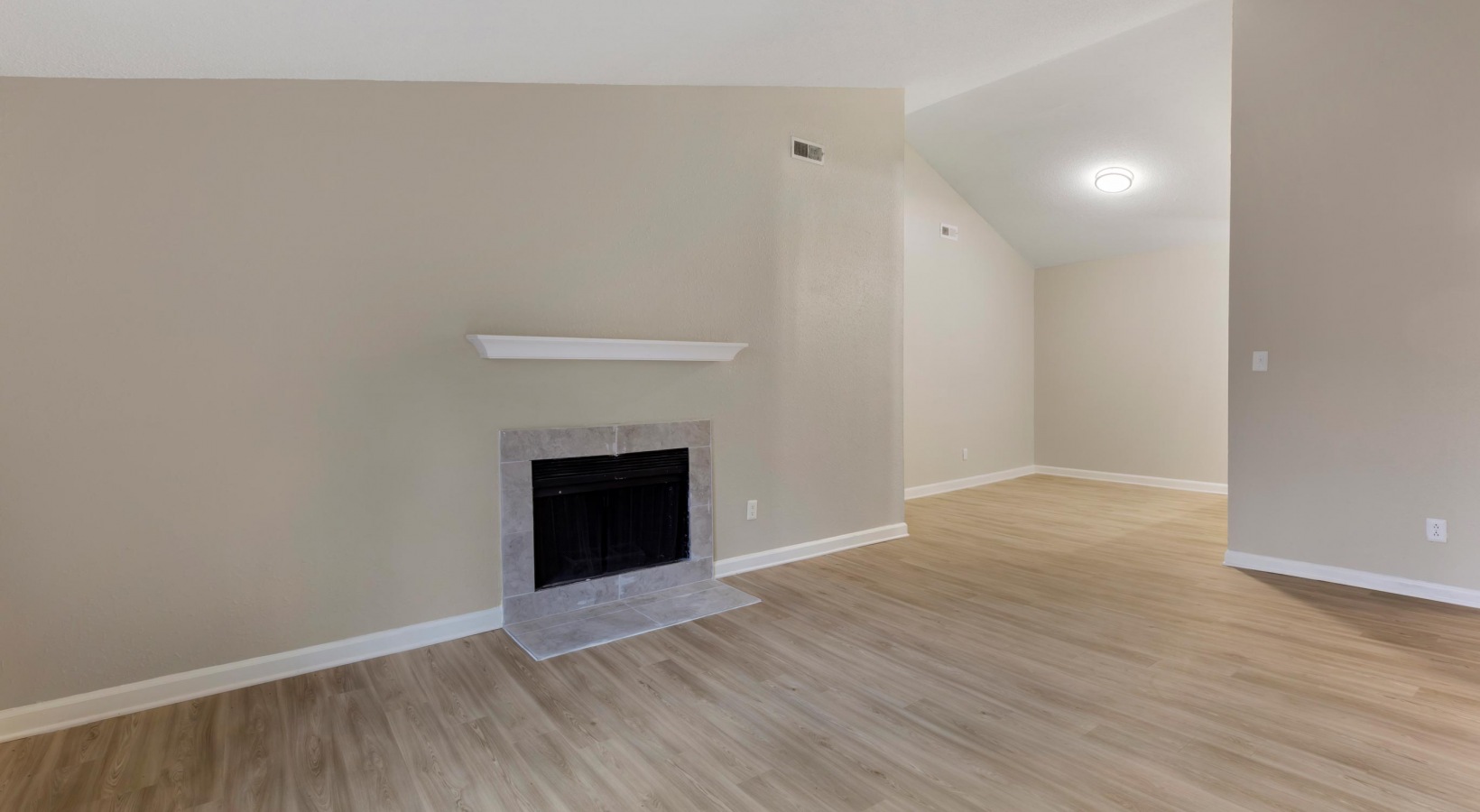 empty living room with fireplace and hardwood floors at The  Sawyer