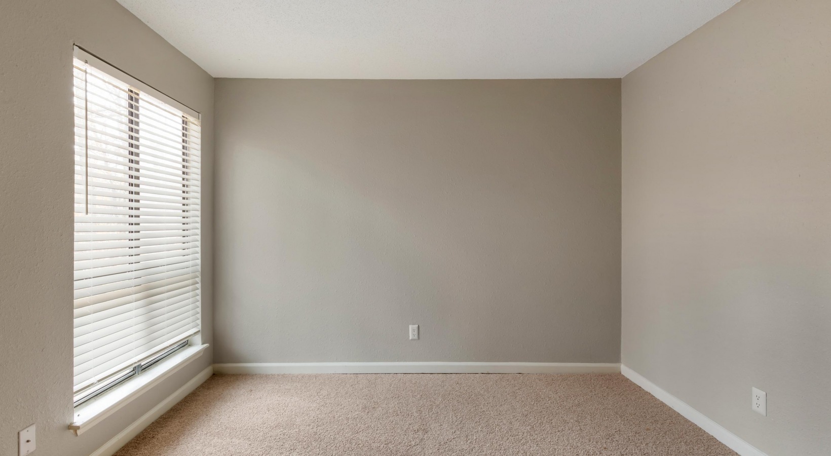 empty room with carpet and beige walls at The  Sawyer