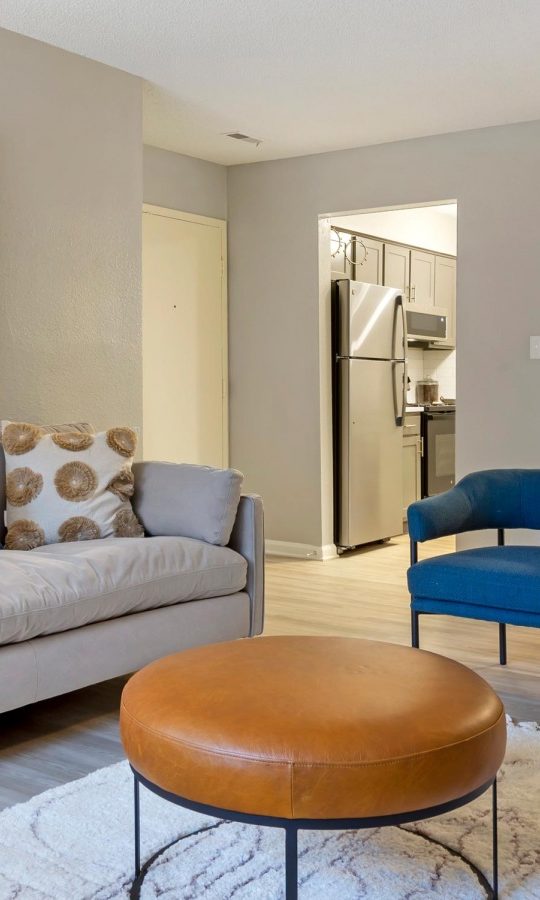 a living room with a couch, chair and ottoman at The Sawyer