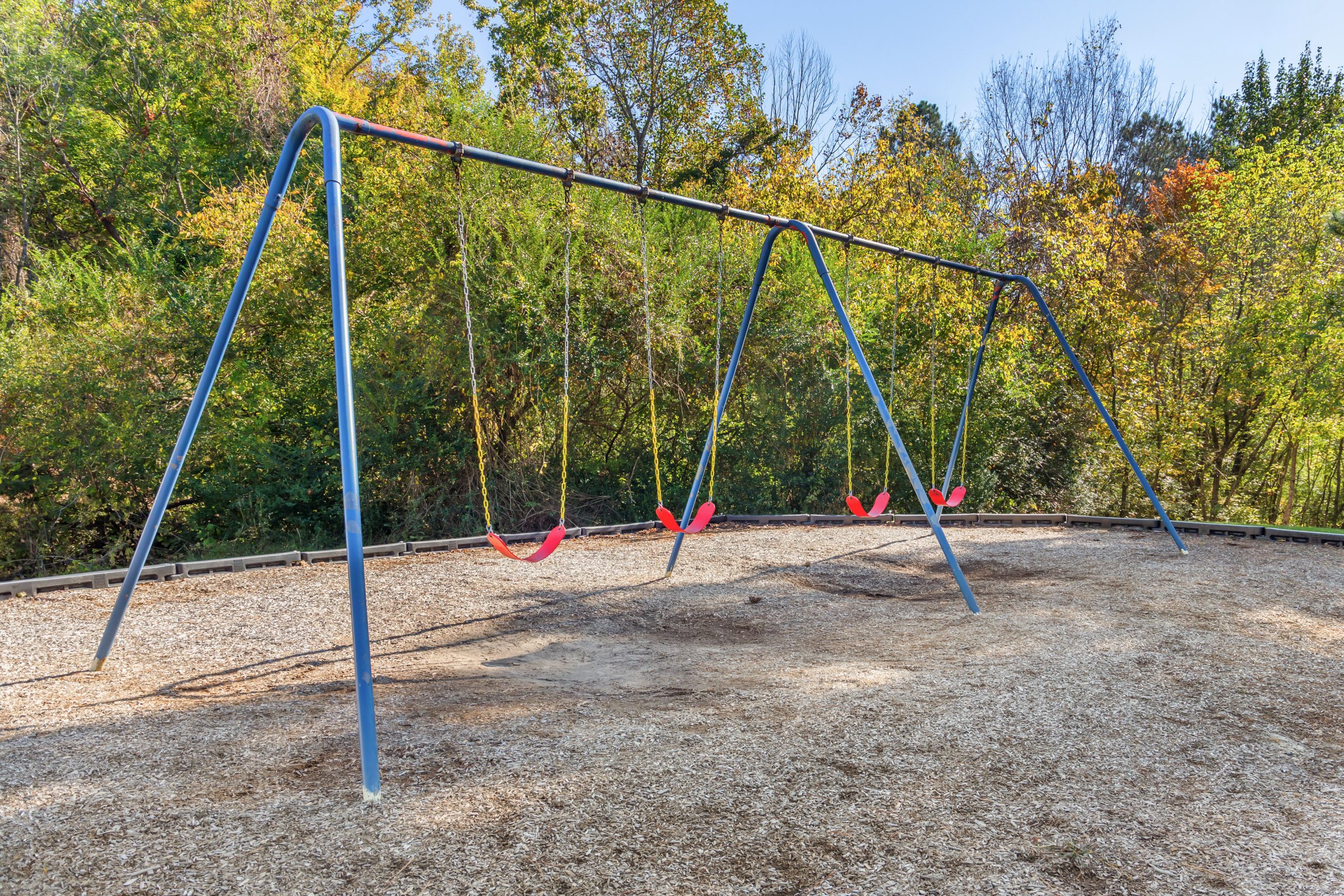 a swing set with two swings and a tree in the background at The  Sawyer