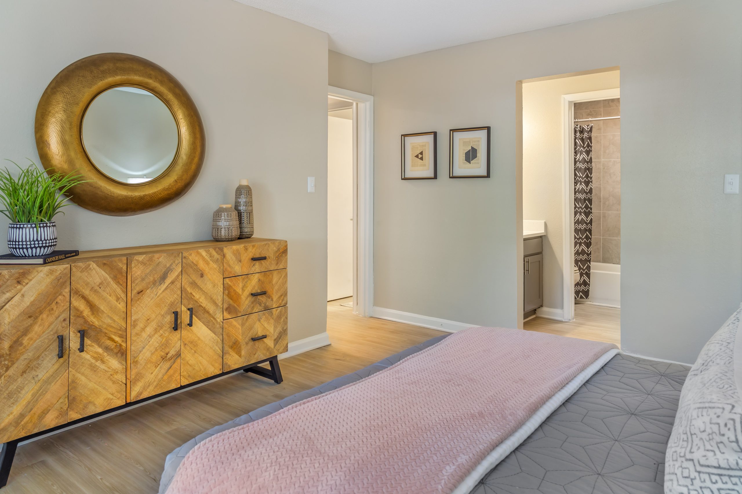 a bedroom with a dresser, mirror and bed at The  Sawyer